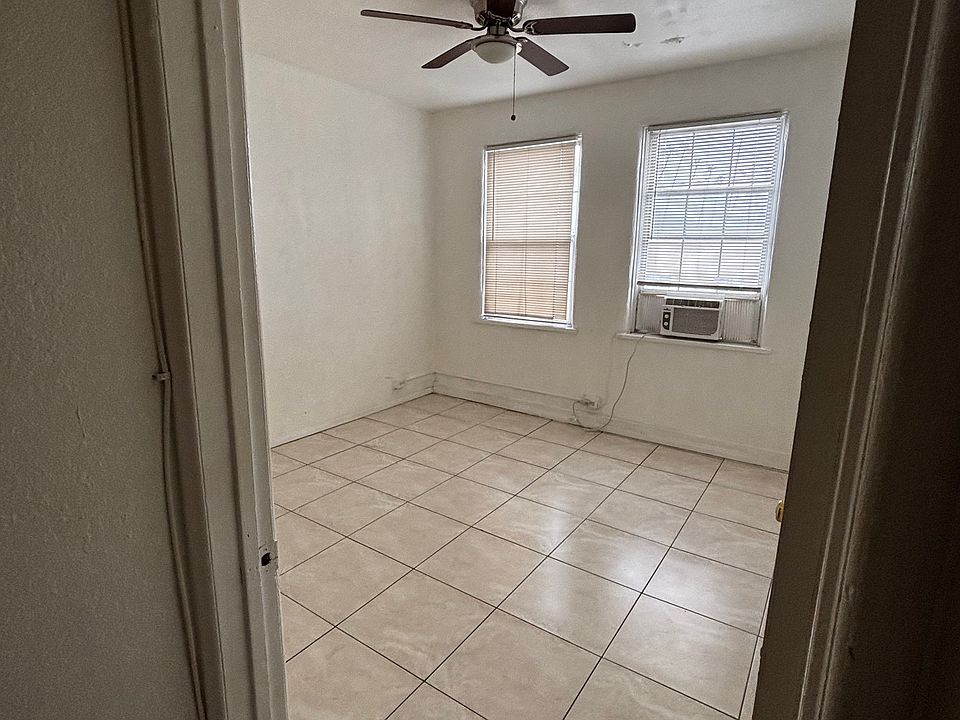 large bedroom with AC window unit and ceiling fan