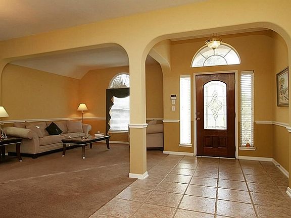 The entry has large tile floors, archways