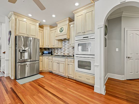 Large Stainless Steel French door refrigerator with 5-burner gas cooktop.