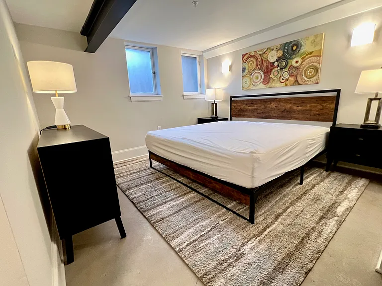 Primary bedroom with king bed. This bedroom has 2 nightstands, a dresser, and 2 chairs.