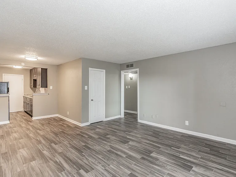 Spacious living areas feature natural light and wood-style flooring at Chapel Creek Apartments.