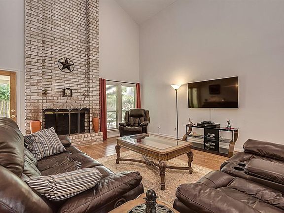 The living room has tall ceilings with Pergo wood floors and a two story brick fireplace.