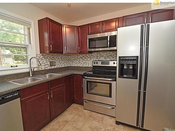 Notice the modern backsplash and stone-look but easy care countertops. Bonus - this refrigerator stays for you!