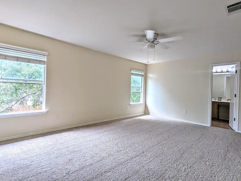 Generous size master bedroom with tree-top and backyard view