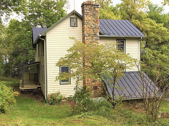 Side view of the house, showing the front porch, fieldstone