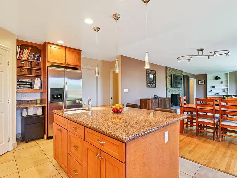 Kitchen/Dining/Living Rooms
(Door to left accesses walk in pantry, door to the right of refrigerator provides access to attached garage with washer/dryer/utility sink and large workbench)
