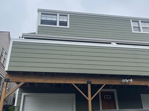 Exterior back of unit with one car garage and two parking spaces