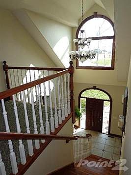 Gorgeous and Dramatic Foyer with large tile and a wood staircase!