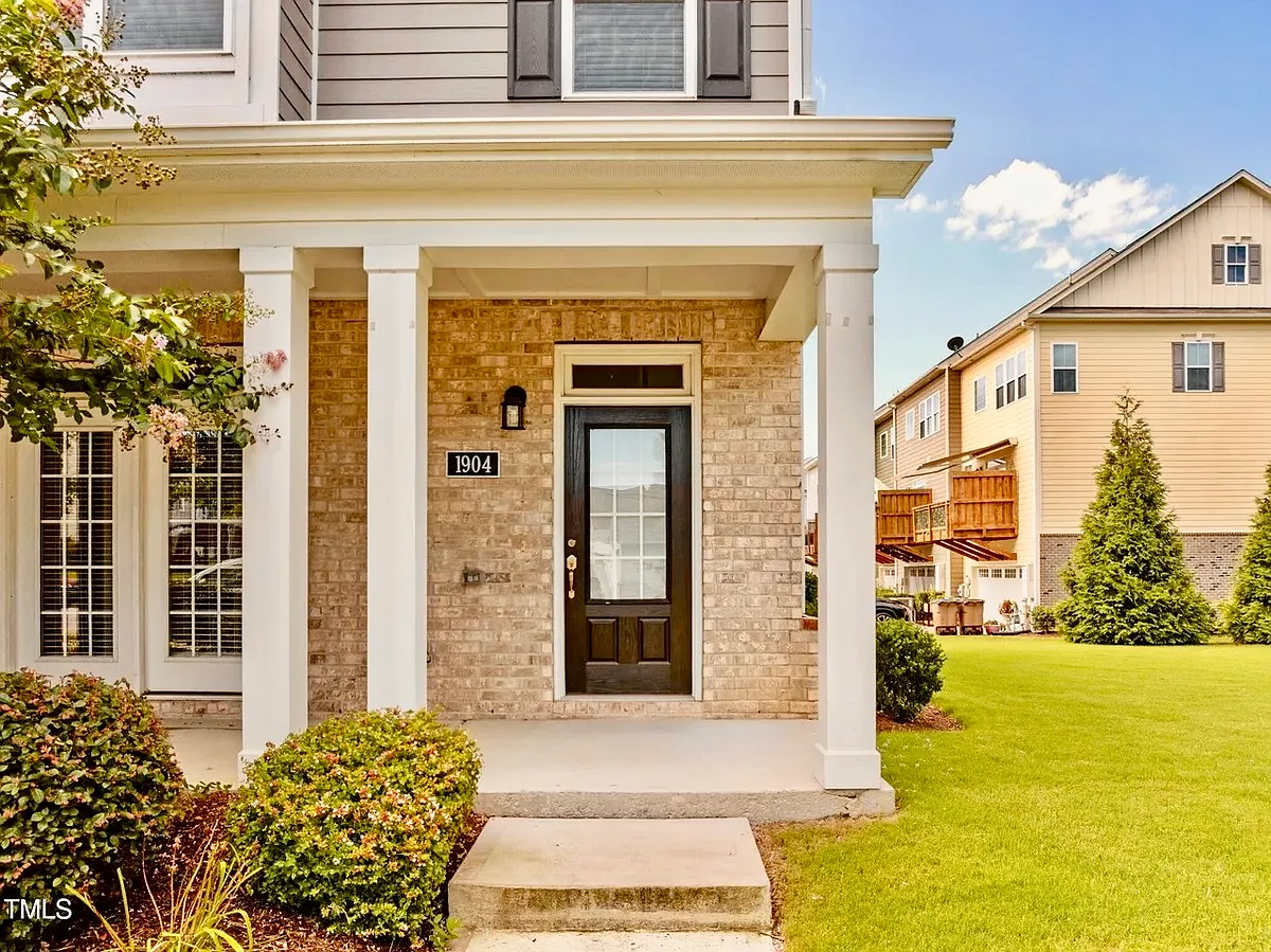Front entrance has covered porch with French doors leading inside. Large grassy area adds to your space with this end unit. - 1904 Austin Ridge Pkwy