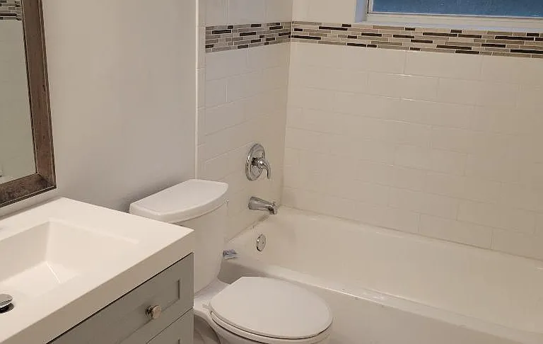 Full size tub, newer chair height toilet.
