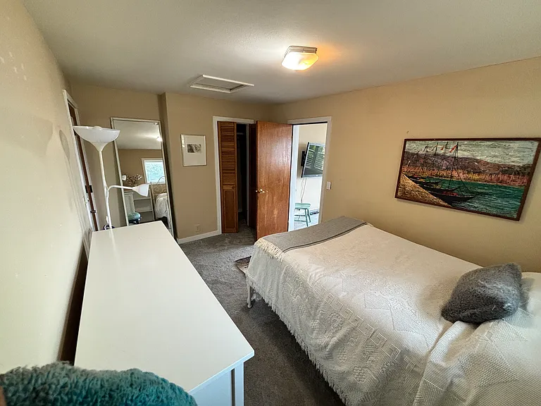 Bedroom with full bed and dresser and closet.