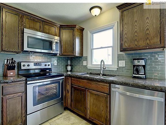Kitchen View. All NEW Featuring: Cabinetry, Sink, Faucet, Lighting, Tile Backsplash, Ceramic Tile Flooring, Polished Concrete Countertops, All Whirlpool Stainless Steel Appliances Stay Including Bottom Drawer Refrigerator, Smoothtop Stove, Dishwasher, & M