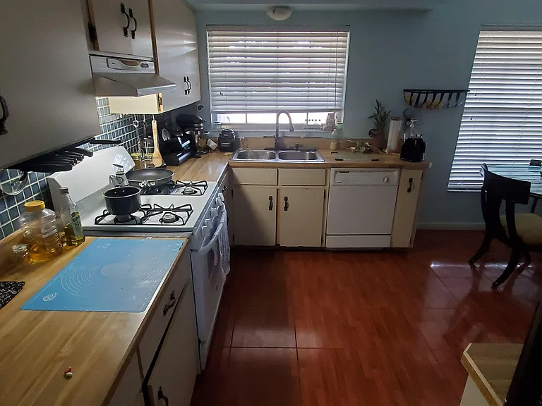 Efficient kitchen with gas range, ample counter space, dishwasher, and adjacent dining area by large windows.