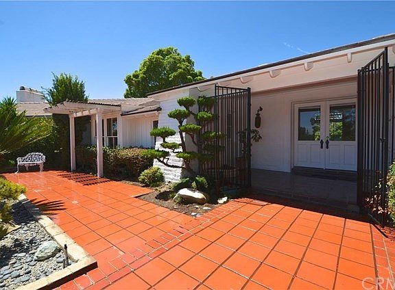 WIDE WALKWAY LEADING TO DOUBLE DOOR COVERED ENTRY AND SITTING AREA