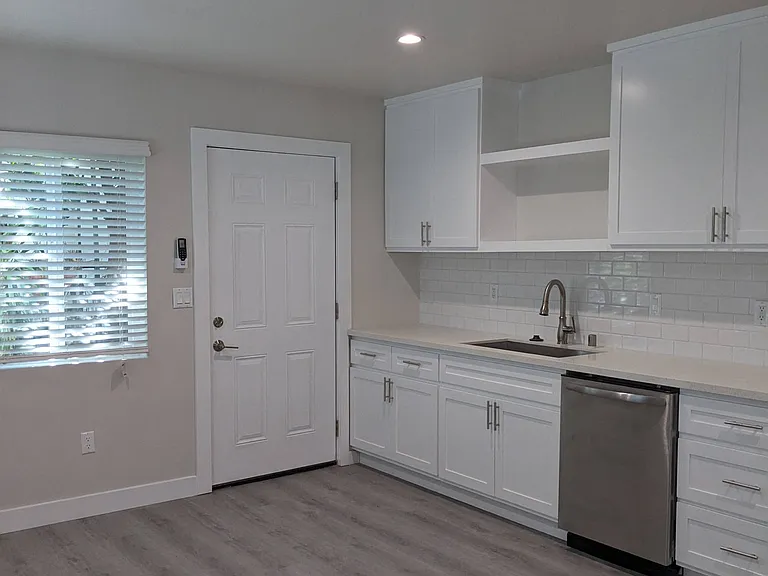 Spacious kitchen with lots of natural light and white cabinets at The Hardison Apartments in Pasadena, California.