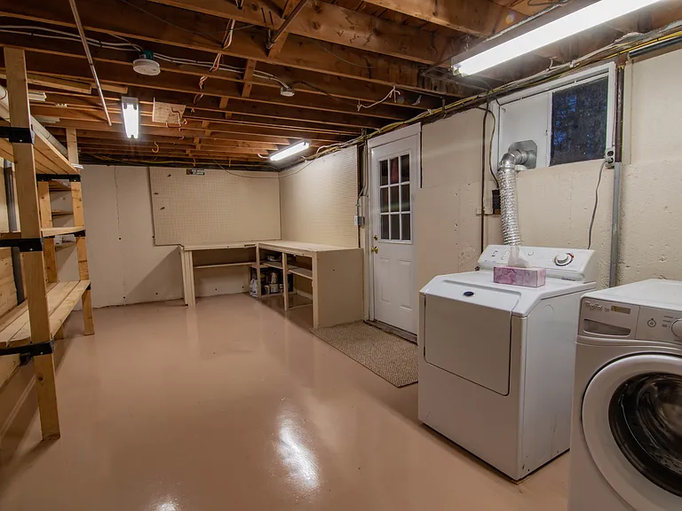 Walkout storage, workbench space with resin flooring. High efficiency washer & gas dryer space with resin flooring.