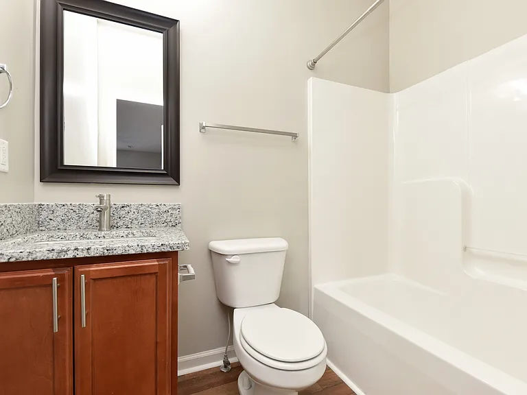 Bright bathroom with granite counters and bathtub