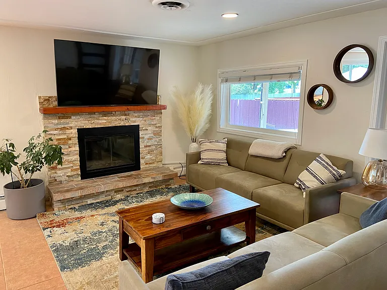 Main level living room: 65 inch smart TV, wood burning fireplace