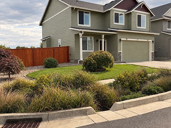 Side-View of the home situated at the edge of the street with grass front yard