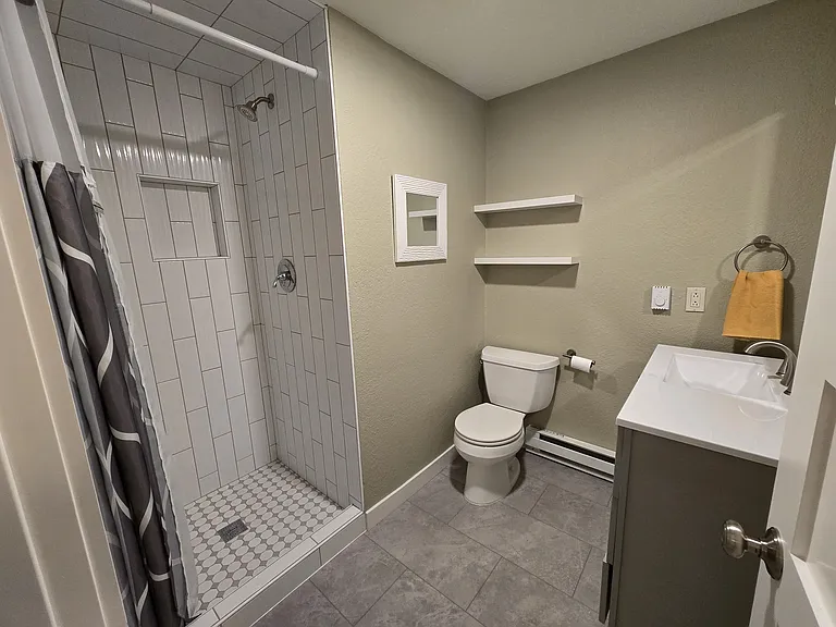 The newly remodeled bathroom with new flooring, tiles, and fixtures. A brand new water heater provides fabulous water pressure.