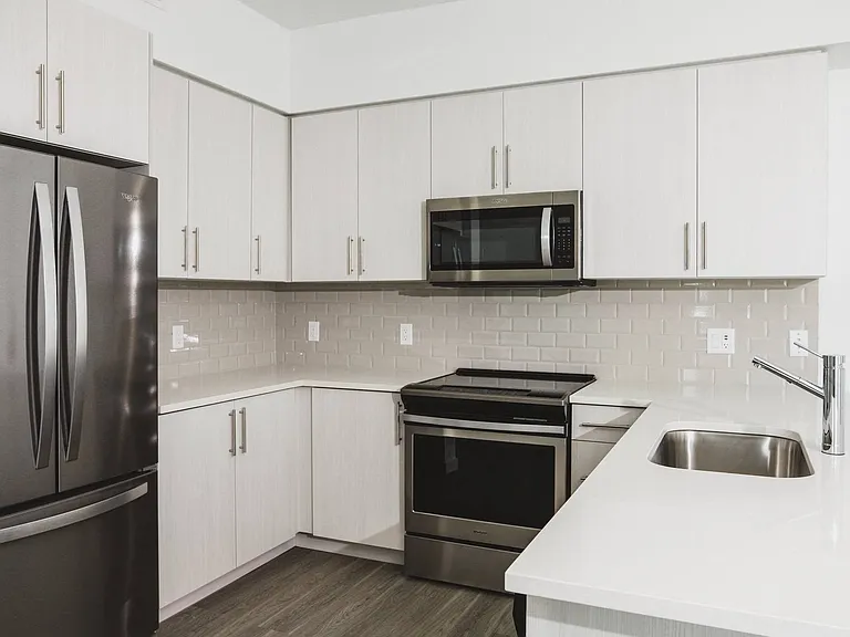 Gourmet kitchens feature quartz countertops and subway-tile backsplash.