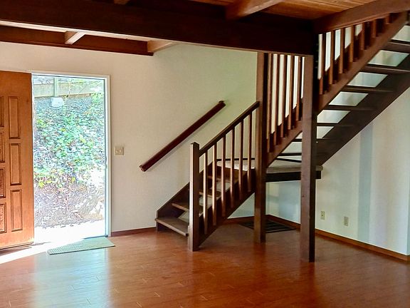 "Floating" wood stairs are architecturally interesting and disappear into the ceiling.