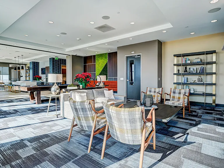 Resident lounge area with bar top seating, catering kitchen, lounge seating, entertainment area, and rooftop pool access