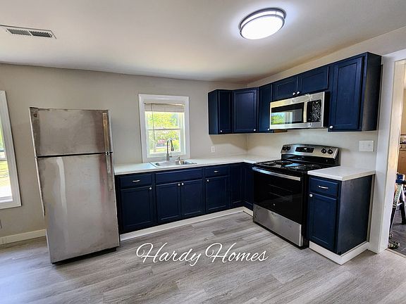 Completely remodeled kitchen with beautiful dark blue cabinets and new stainless steel appliances.