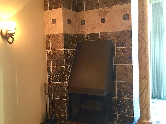 Real Wood burning Fireplace finished in Emperador Dark Marble and Travertine