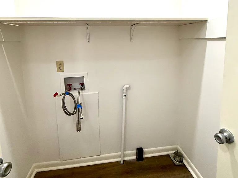 Further down the hallway is this spacious laundry closet that will easily hold a full size washer and dryer. There is a shelf to conveniently put your laundry detergent, softener and stain removal products. It runs the length of the entire area.