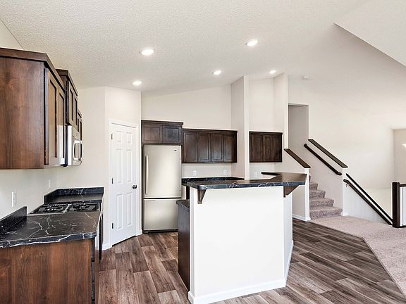 The open kitchen of the St. Harrison features a spacious island and stainless steel appliances.