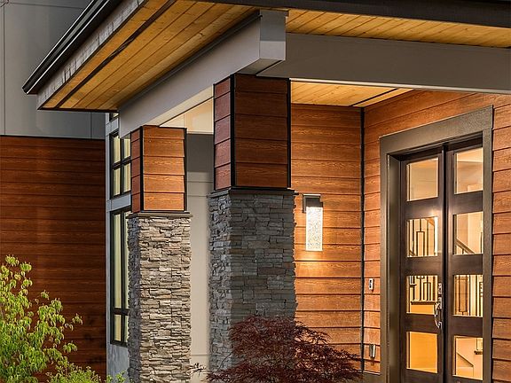 Beautiful arrival with a welcoming covered front porch and a double door entry.>