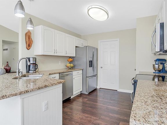 Updated kitchen with granite counters, stainless appliances & hand scraped hardwood flooring.