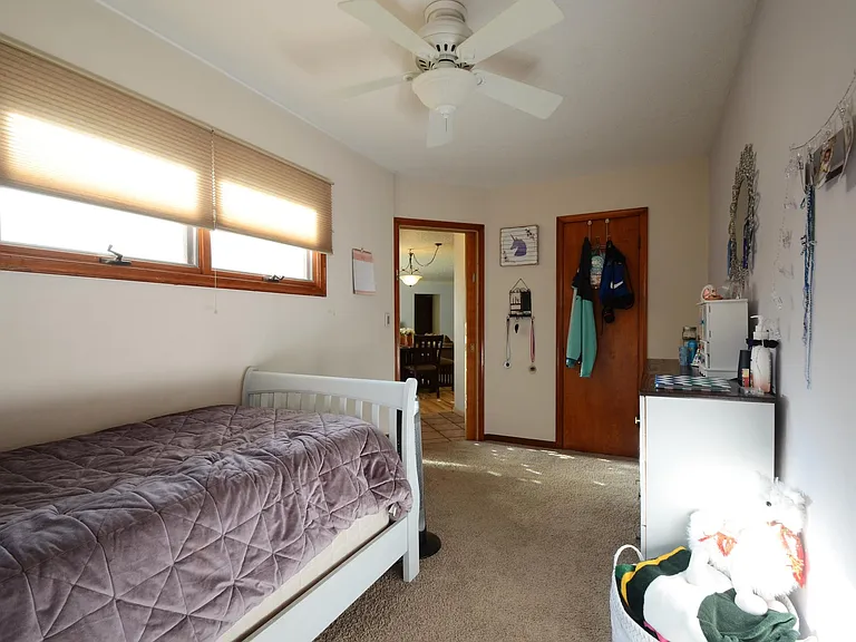 3rd Bedroom or Main Level Office. Carpeted floor. Ceiling fan. Raised awning-style windows provide privacy and invite in the sunshine.