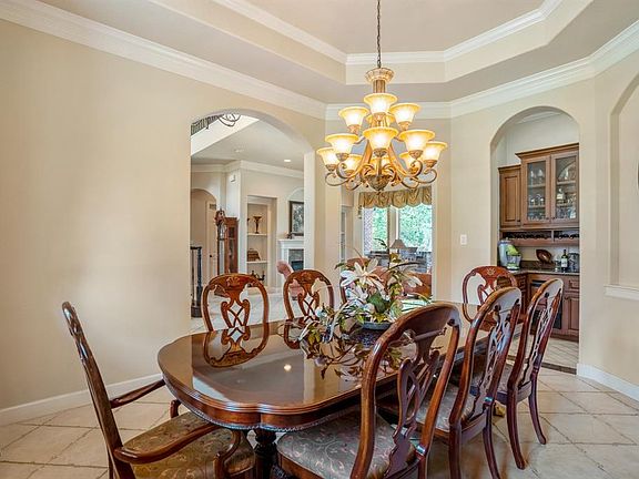 Large elegant dining room with art niche, trayed ceiling with two tone paint palette.