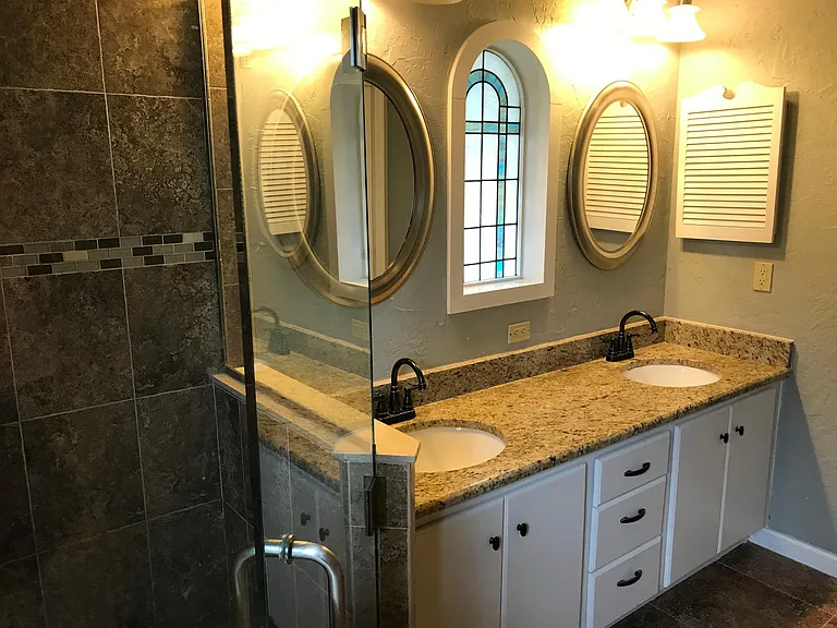 Updated master Bath has frameless shower door and granite counters