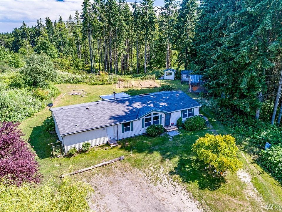 This 2004 manufactured home has 1980 square feet, a newer roof, and two master bedrooms.  There are 3 bedrooms plus a den/office that can serve as a 4th bedroom as there is a 4-bedroom gravity septic system. There are also 3 full bathrooms, a woodstove, and a 700 square foot deck on 5.26 acres of beautiful land.