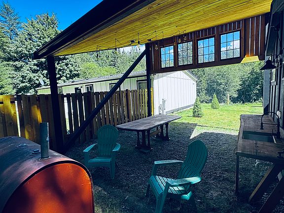 Outdoor area has kitchen sink, and bartop, dining room table and firepit