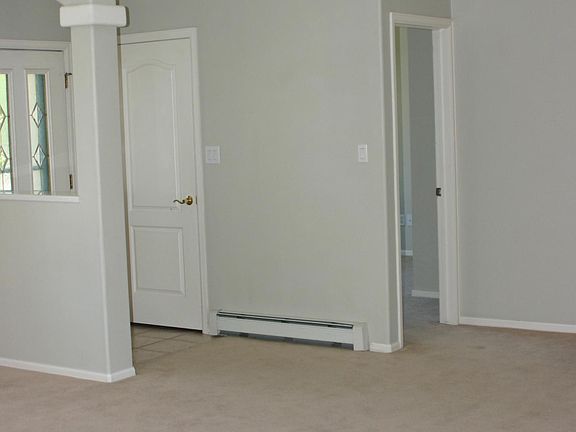High ceilings looking to a bedroom and front door.