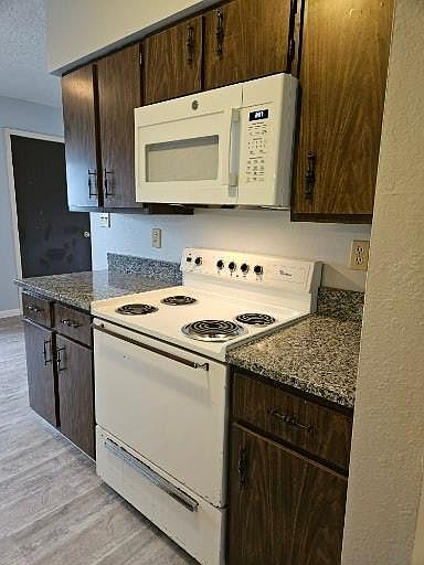 Granite countertops, electric stove and over the stove microwave.