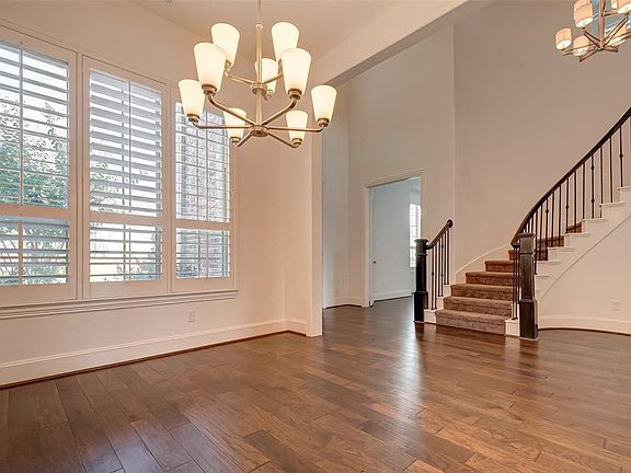 Another view of the formal dining area with custom plantation shutters. The perfect setting for festive entertaining and private dinner parties. The double doors to the left of the staircase lead through to the home study.