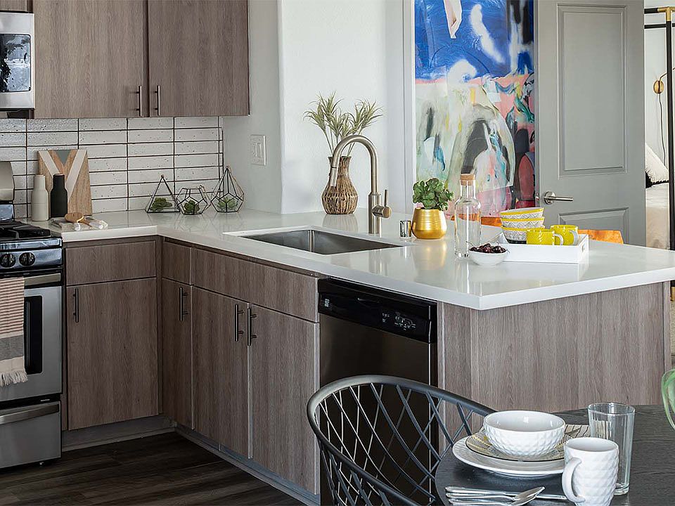 Apartment Kitchen with Stainless Steel Appliances, quartz counters and wood floors.