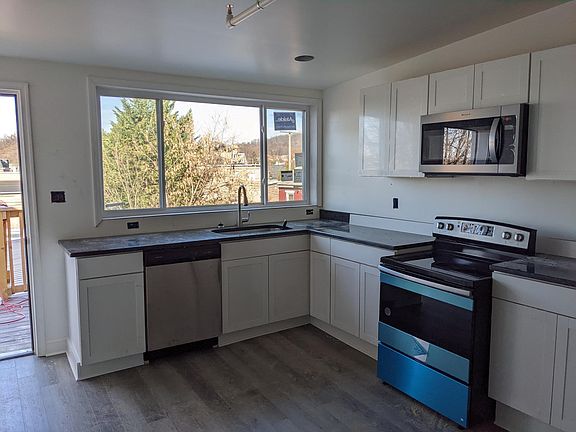 Kitchen with granite counters, dishwasher, and pull down faucet with sprayer