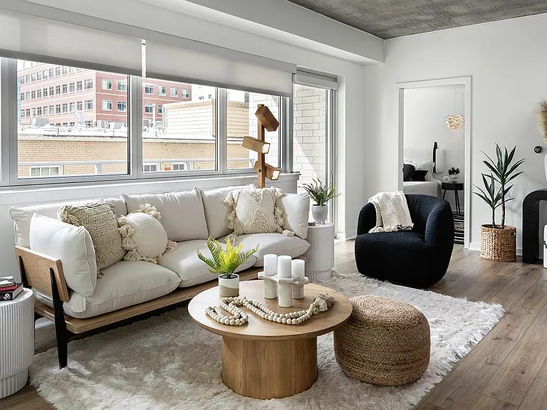 Apartment living room with wood-style flooring and balcony or patio in select homes.