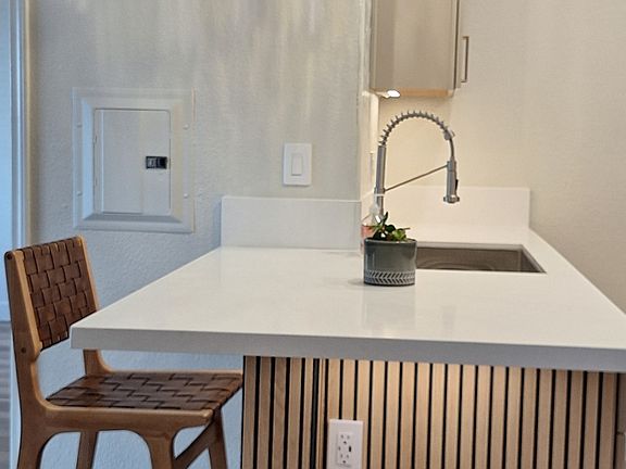 Breakfast bar with wood paneling and designer pendant lighting.