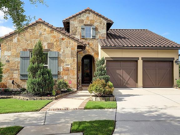 Darling Homes striking stone and stucco front elevation with a tile roof.