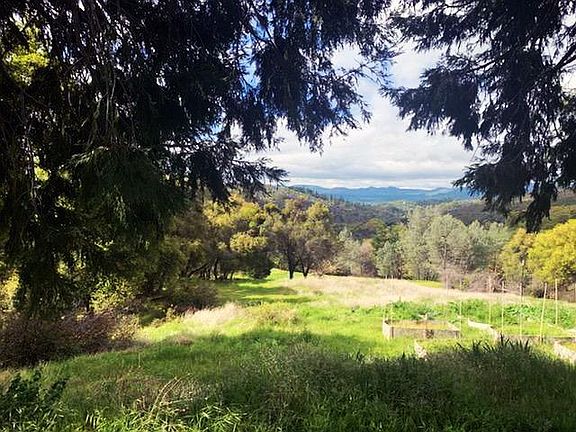 This is a view from the house looking southwest. About a 30-40 mile view. All the open property you see comes with the 7 acres the house sits on. Raised garden can be seen in the right side of photo