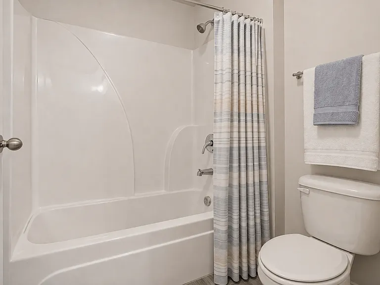 Secondary bathroom with a double vanity and shower-tub combination.
