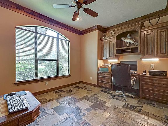 Work from home in elegance and style in this spacious study with custom built in wood desk and cabinetry!