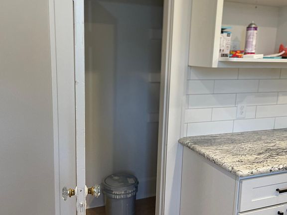 STORAGE OFF KITCHEN WITH LOTS OF STORAGE SHELVES.